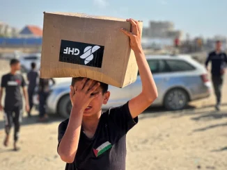 People gather to collect aid from the US-backed Gaza Humanitarian Foundation, in Rafah, southern Gaza Strip, on 27 May